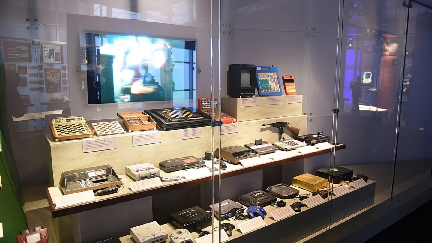 Un casete antiguo y un ordenador histórico junto a una emulación moderna de videojuego