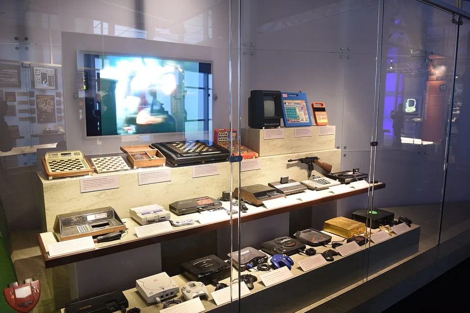 Un casete antiguo y un ordenador histórico junto a una emulación moderna de videojuego