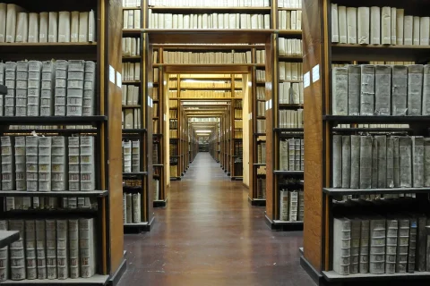 Investigadores consultan un catálogo digital en una gran sala de lectura