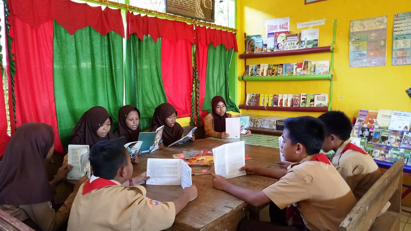 Un grupo de personas lee en silencio distintos libros alrededor de una mesa