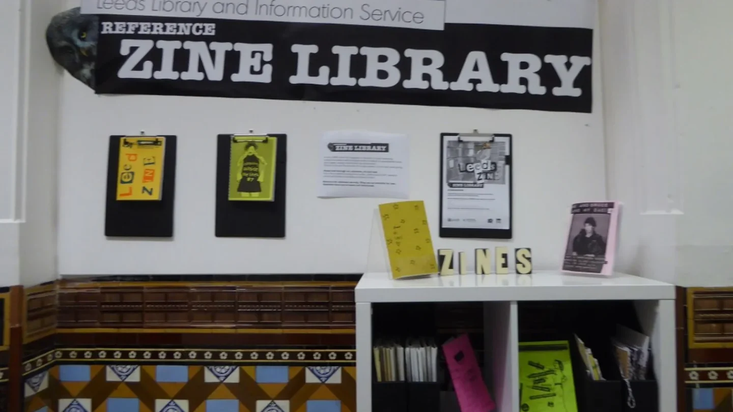 Manos organizan fanzines y documentos de una comunidad de fans.
