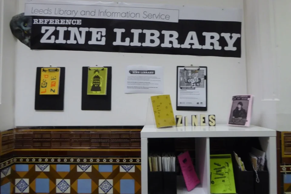Manos organizan fanzines y documentos de una comunidad de fans.
