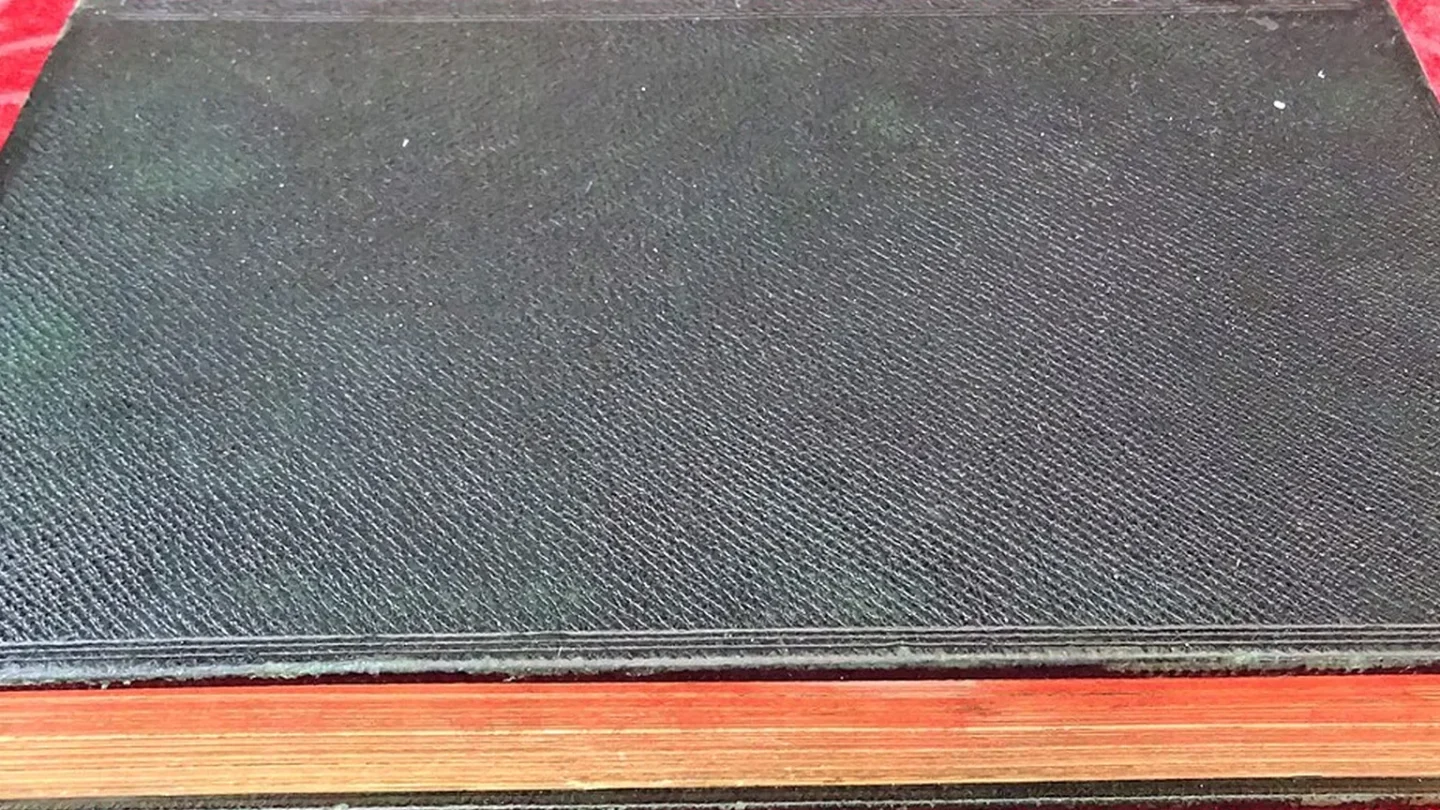 Las páginas abanicadas de un libro revelan un paisaje pintado que estaba oculto.