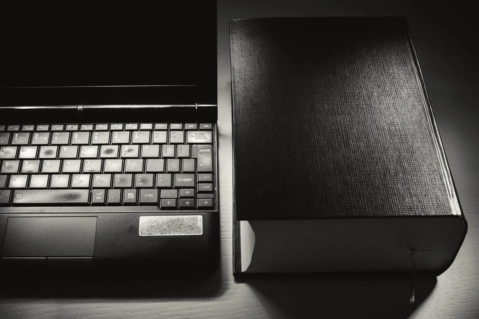 Lector electrónico y disco externo junto a un cuaderno de inventario.