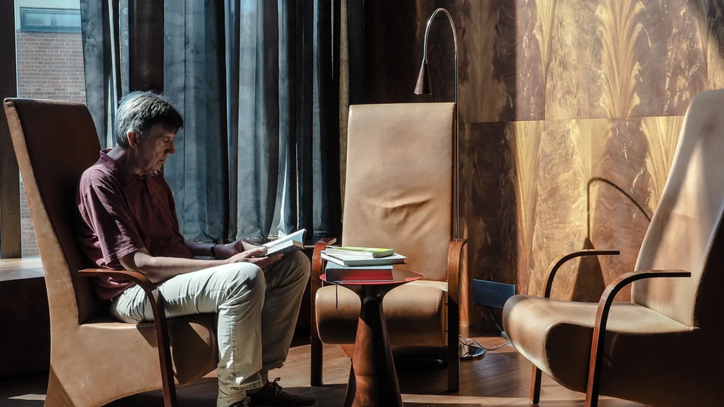 Personas de distintas edades leyendo en papel y digital dentro de una biblioteca pública