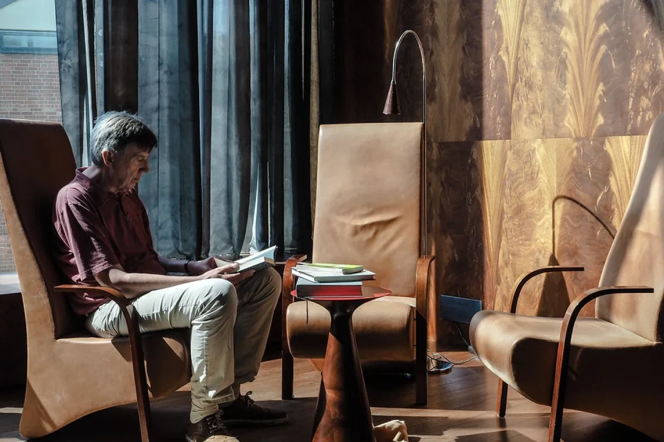 Personas de distintas edades leyendo en papel y digital dentro de una biblioteca pública