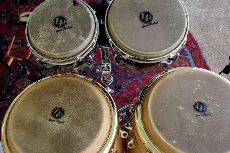 Instrumentos acústicos y electrónicos reunidos alrededor de una mesa de mezcla