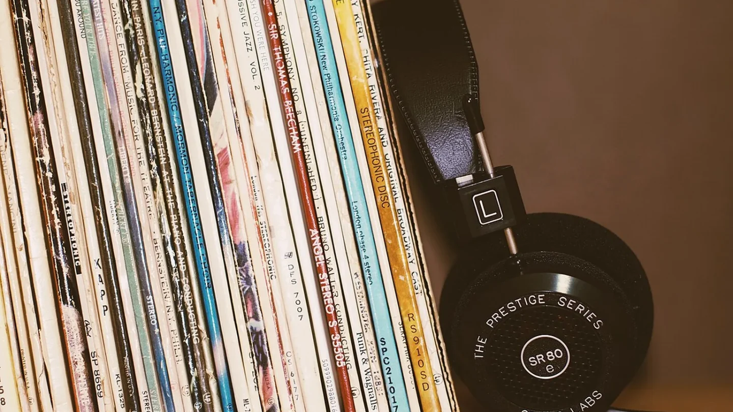 Teléfono, vinilo y ondas de audio sobre un mapa que representa el mercado musical mundial