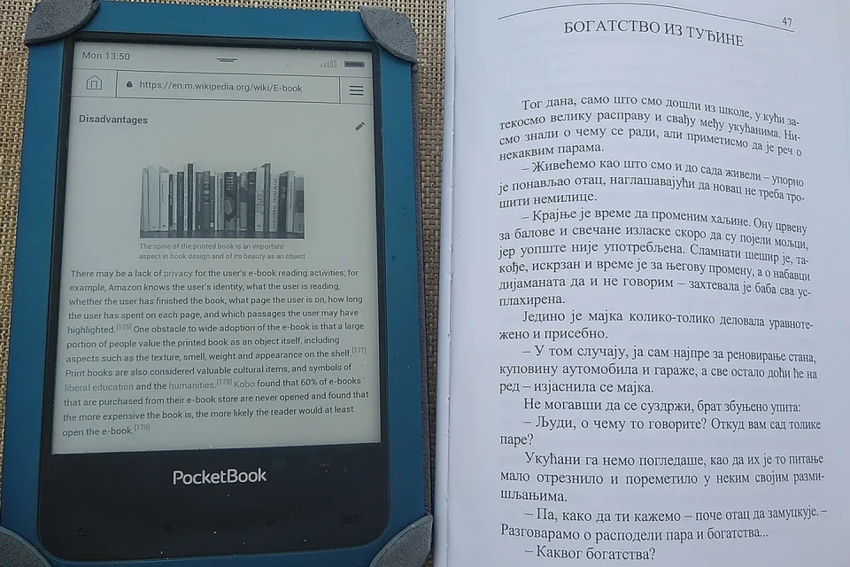 Una persona consulta un ebook en una biblioteca con libros impresos al fondo.