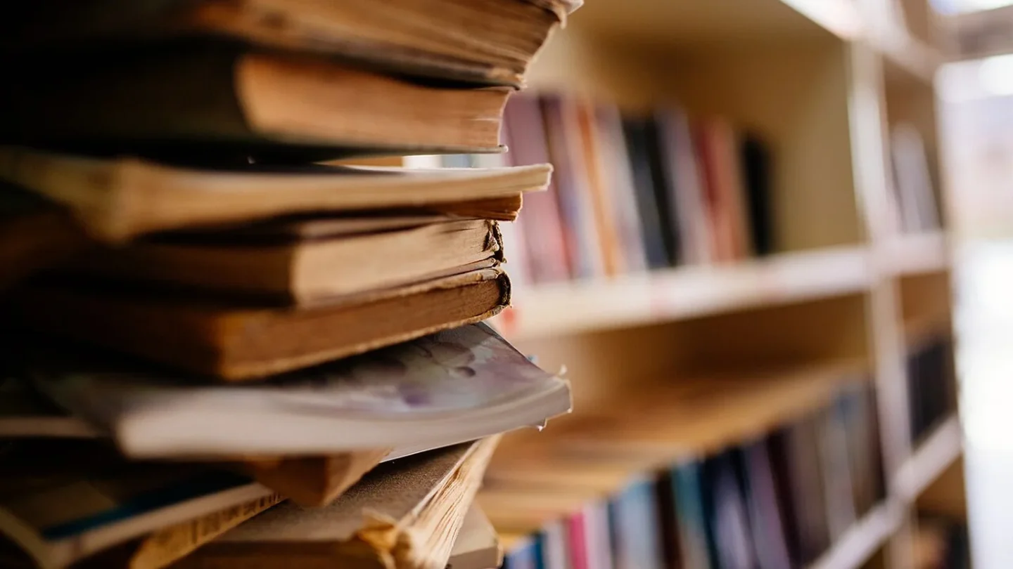Detalle de las páginas envejecidas de un libro antiguo en una biblioteca.