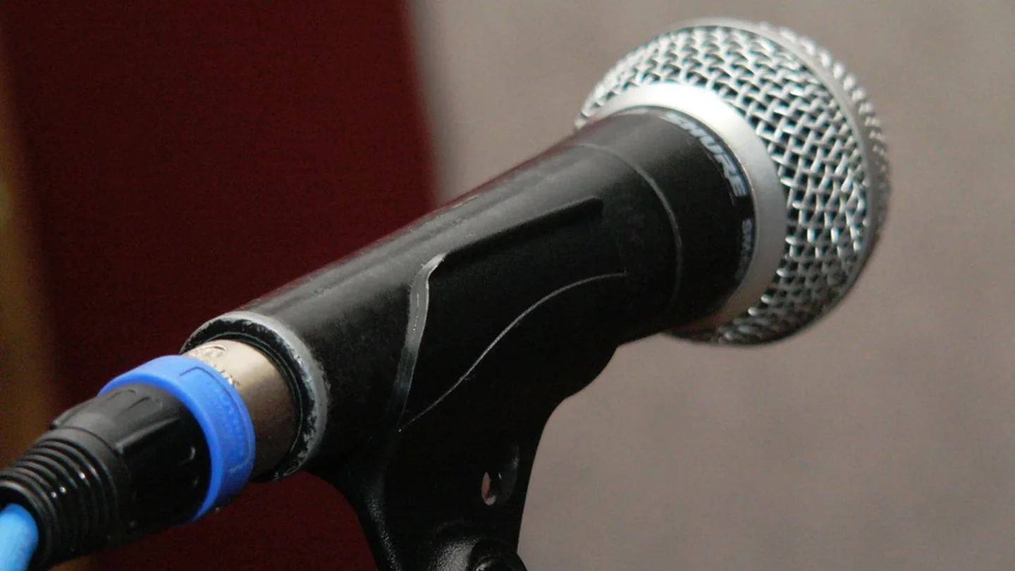 Un músico consulta braille musical junto a una partitura digital accesible.