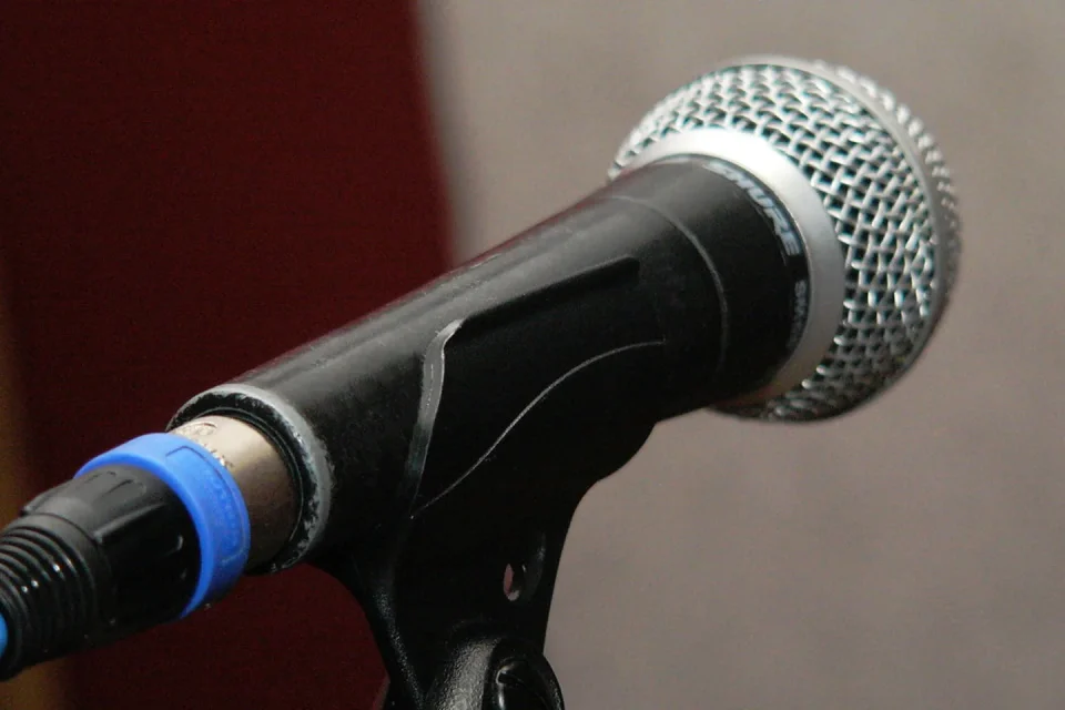 Un músico consulta braille musical junto a una partitura digital accesible.