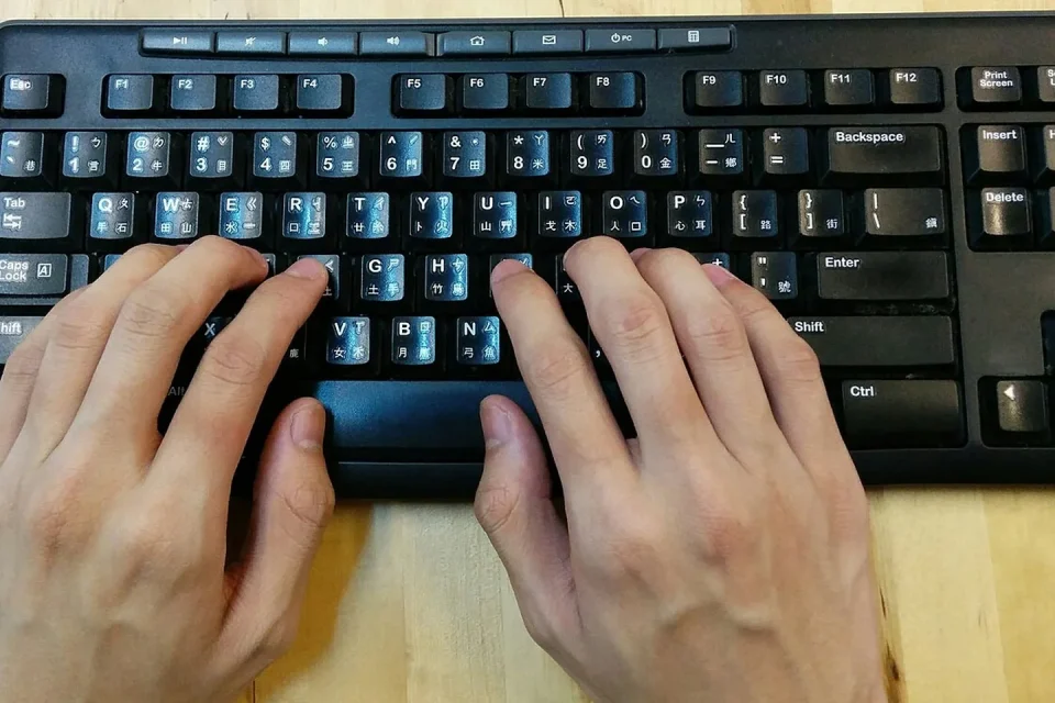 Caracteres de varias escrituras conectados visualmente con un teclado y una pantalla